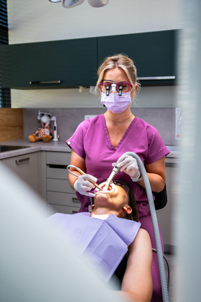 Dental hygienist performing professional dental hygiene on a patient at M2 Stoma